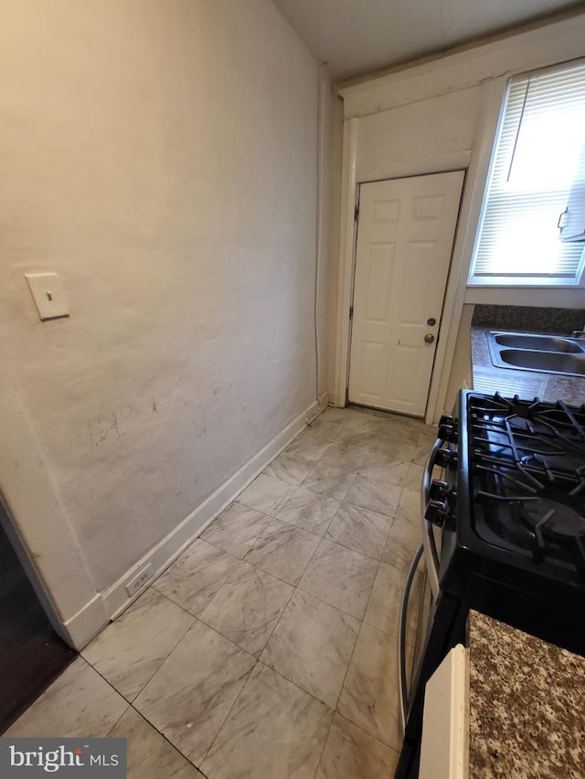 kitchen featuring black gas range and sink