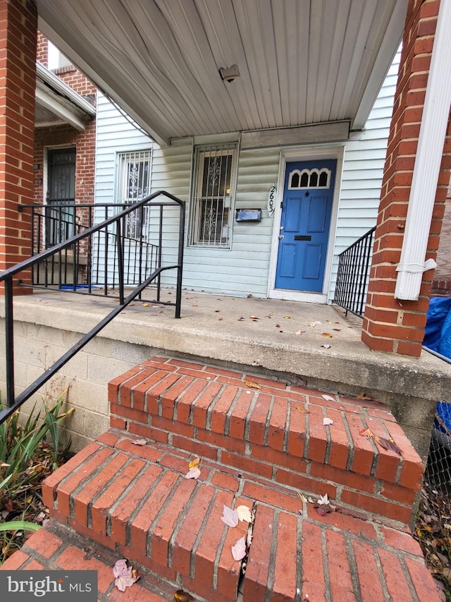 view of exterior entry featuring covered porch