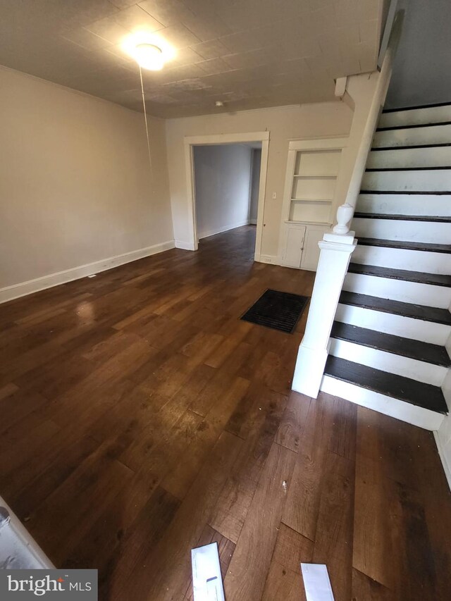 staircase featuring built in shelves and hardwood / wood-style flooring