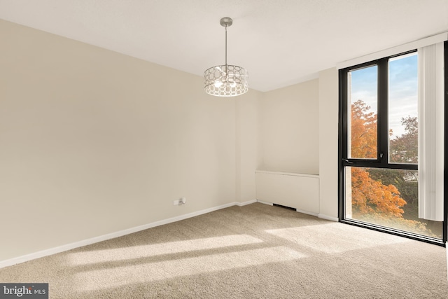 spare room with carpet floors and a notable chandelier