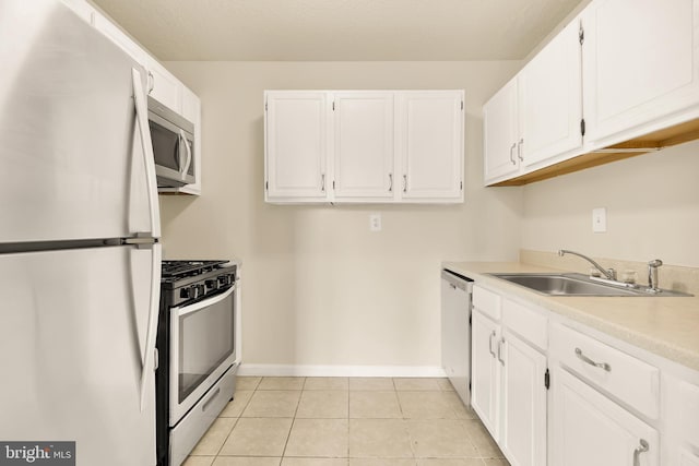 kitchen with white cabinetry, appliances with stainless steel finishes, sink, and light tile patterned floors