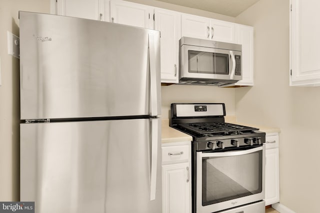 kitchen with white cabinets and appliances with stainless steel finishes