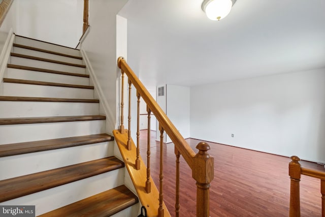 stairs featuring hardwood / wood-style floors