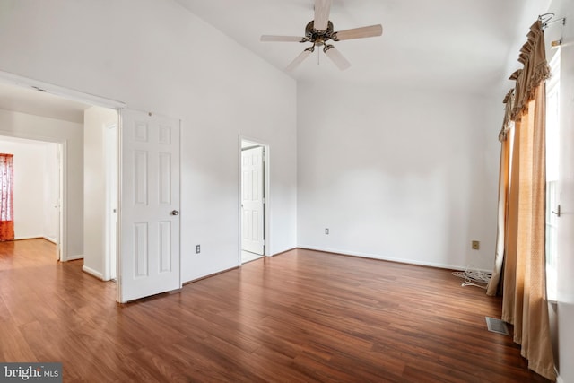 unfurnished bedroom with dark wood-type flooring, high vaulted ceiling, and ceiling fan