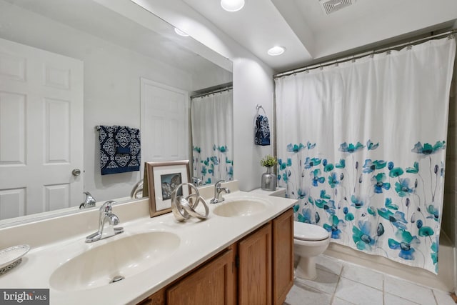 bathroom with toilet, vanity, and tile patterned floors