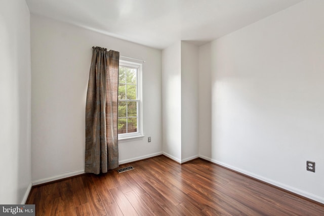 empty room with dark hardwood / wood-style flooring