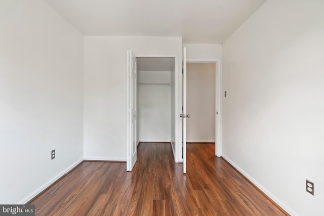 unfurnished bedroom featuring a closet and dark hardwood / wood-style floors