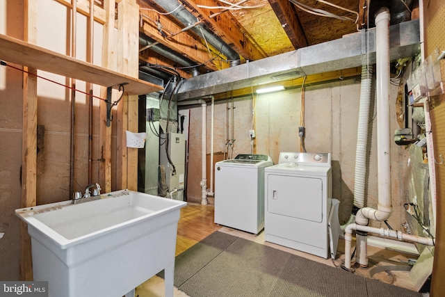 laundry area with light hardwood / wood-style floors, sink, and independent washer and dryer