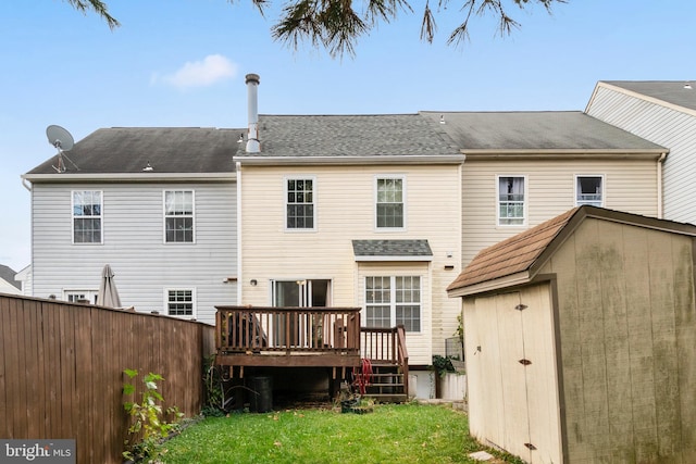 back of house featuring a deck, a storage unit, and a yard