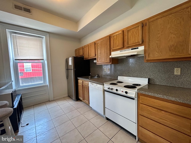 kitchen featuring tasteful backsplash, white appliances, sink, and light tile patterned floors