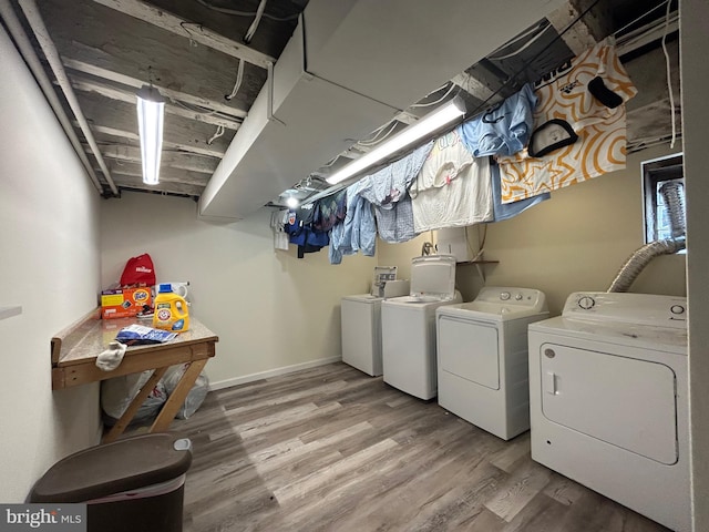 clothes washing area featuring wood-type flooring and washer and dryer