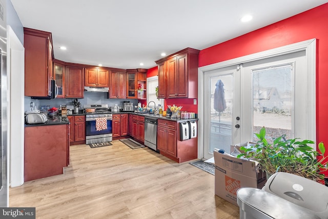 90 Torrington Ln, Willingboro, NJ 08046 - kitchen featuring stainless steel appliances, under cabinet range hood, dark countertops, a sink, and light wood-style flooring