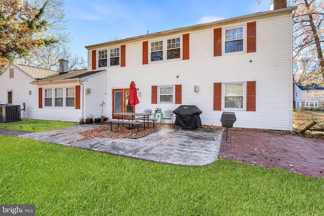 90 Torrington Ln, Willingboro, NJ 08046 - view of front facade with central air condition unit, a patio, a front yard, and a chimney