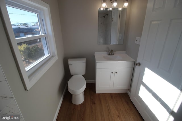 bathroom with vanity, a healthy amount of sunlight, toilet, and wood-type flooring