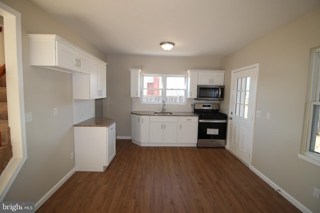 kitchen featuring dark hardwood / wood-style flooring, appliances with stainless steel finishes, sink, and white cabinets