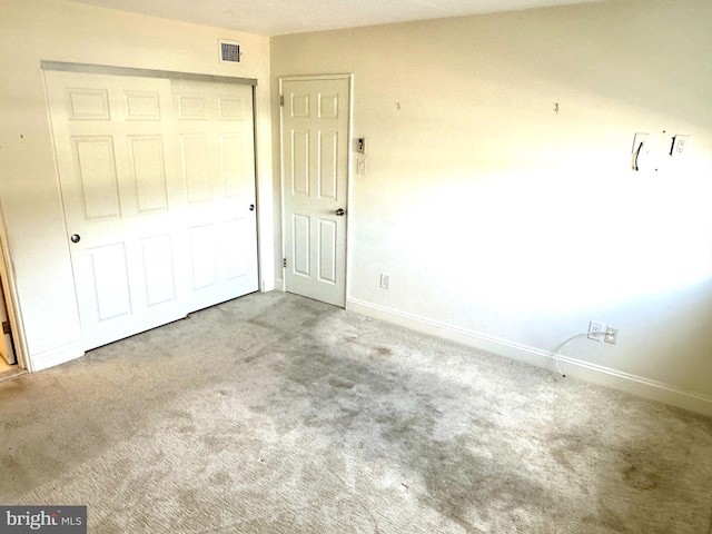 unfurnished bedroom featuring carpet flooring and a closet