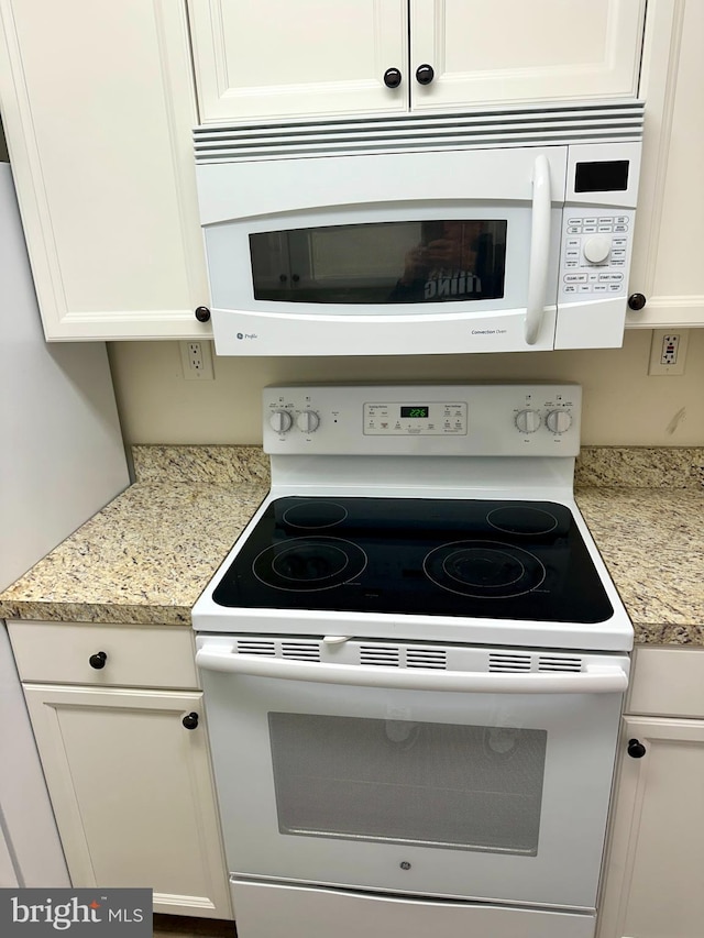 kitchen with white appliances and white cabinetry