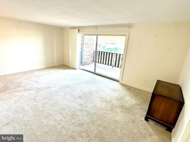 carpeted spare room with a textured ceiling