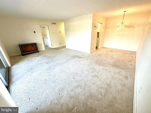 unfurnished living room with carpet and a chandelier