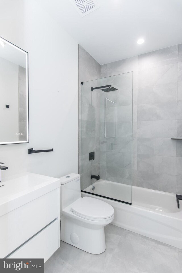 full bathroom featuring toilet, tiled shower / bath combo, and vanity