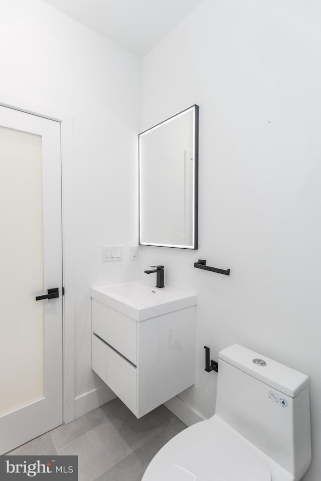 bathroom featuring tile patterned flooring, vanity, and toilet