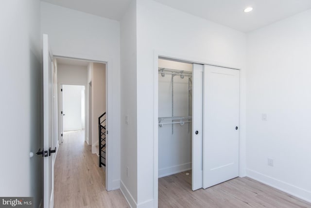 unfurnished bedroom with a closet and light wood-type flooring