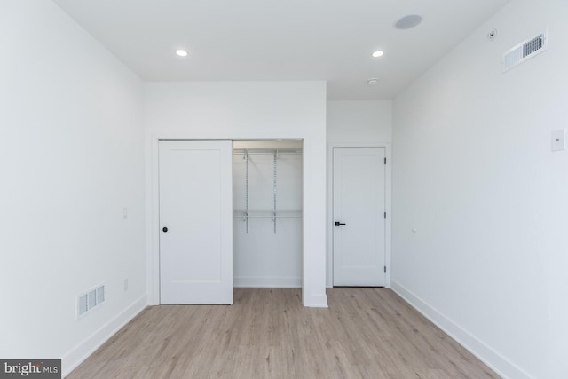 unfurnished bedroom with light hardwood / wood-style floors and a closet