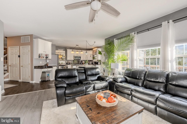 living room featuring ceiling fan and hardwood / wood-style floors