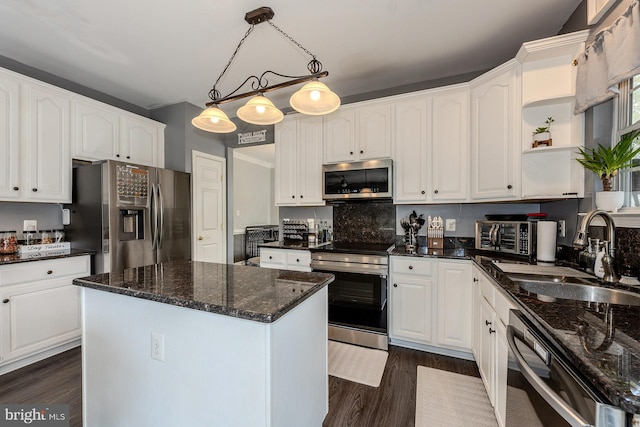 kitchen with decorative light fixtures, a center island, stainless steel appliances, and white cabinetry