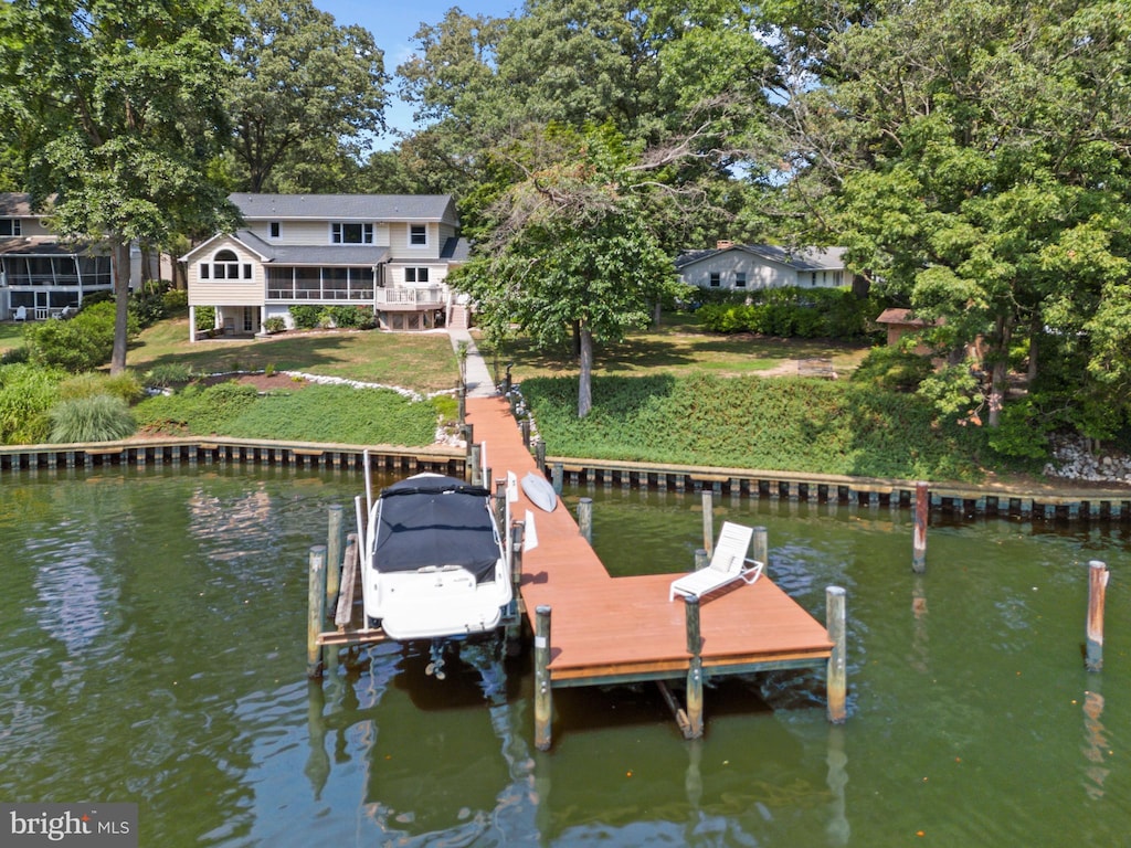 view of dock with a yard and a water view