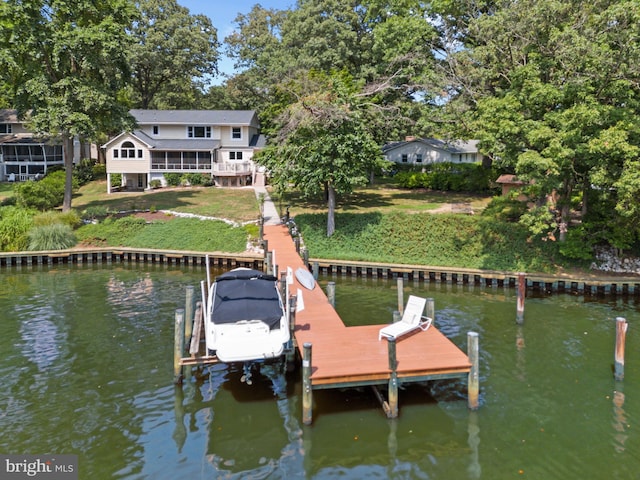 view of dock with a yard and a water view