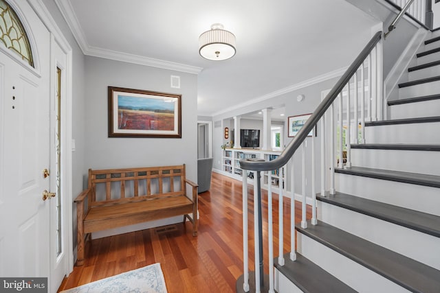 entryway with hardwood / wood-style floors and ornamental molding