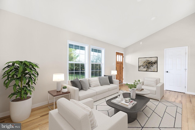 living room with light wood-type flooring and high vaulted ceiling