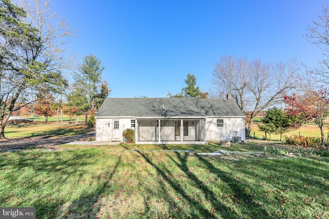 rear view of property featuring a lawn