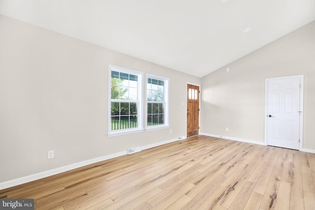 unfurnished room with high vaulted ceiling and light hardwood / wood-style flooring