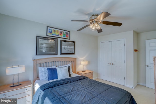 carpeted bedroom with ceiling fan and a closet