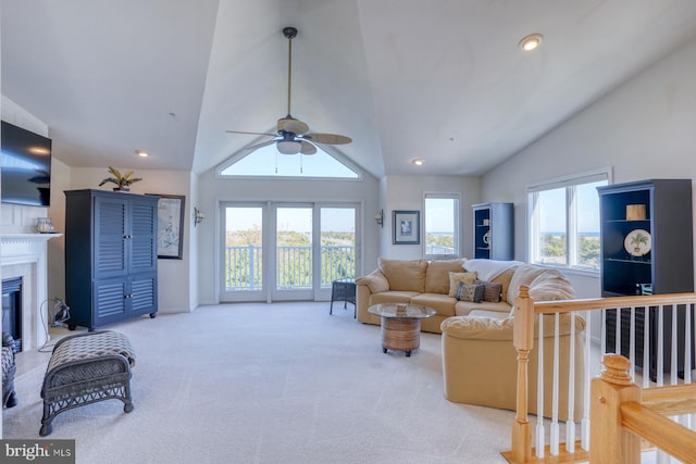 living room with high vaulted ceiling, light colored carpet, and ceiling fan