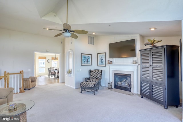 carpeted living room with high vaulted ceiling and ceiling fan