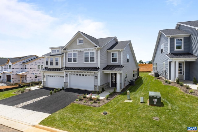 view of front of property featuring a garage, central AC, and a front lawn