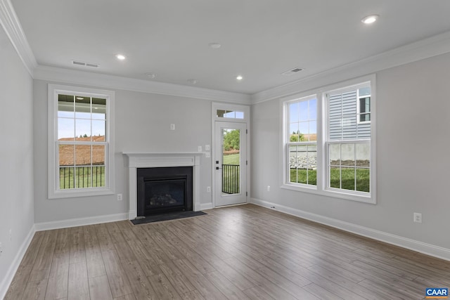 unfurnished living room with ornamental molding, hardwood / wood-style floors, and a healthy amount of sunlight