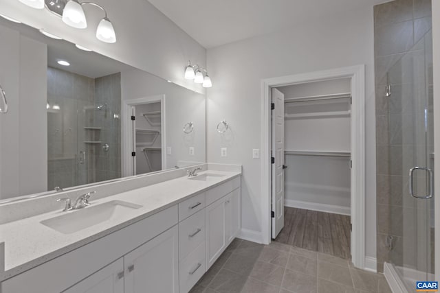 bathroom with tile patterned flooring, an enclosed shower, and vanity