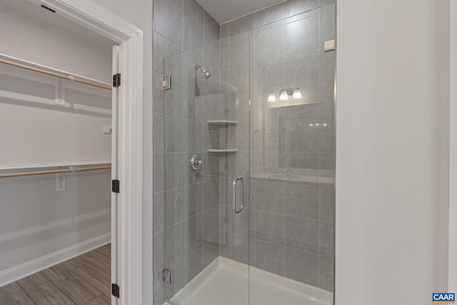 bathroom with wood-type flooring and a shower with shower door