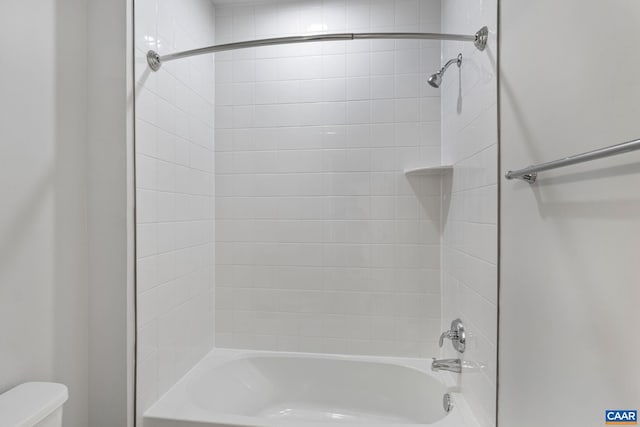 bathroom featuring toilet and tiled shower / bath combo