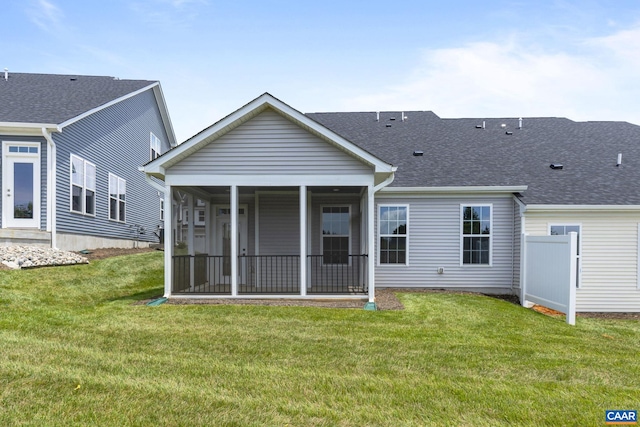 back of property with a sunroom and a yard