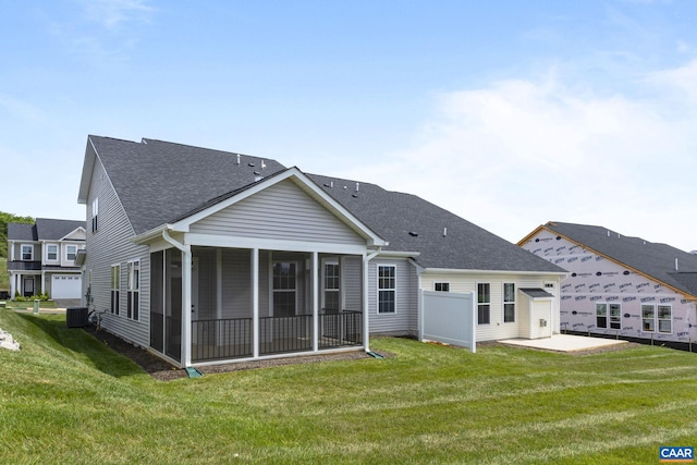 back of property with central AC, a sunroom, and a yard