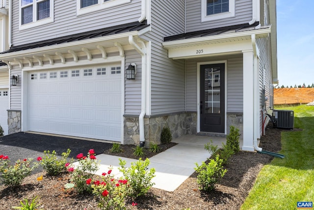 entrance to property with a garage and central air condition unit