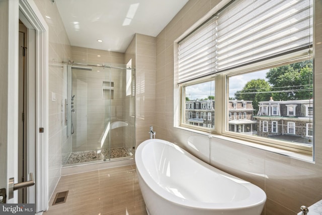 bathroom featuring tile walls, plus walk in shower, and tile patterned flooring