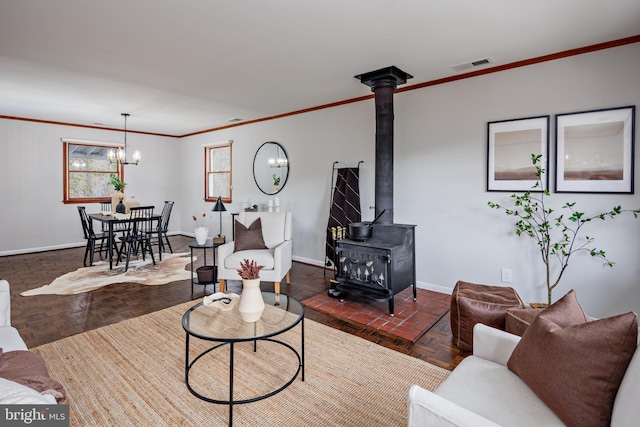 living room featuring an inviting chandelier, a wood stove, and crown molding