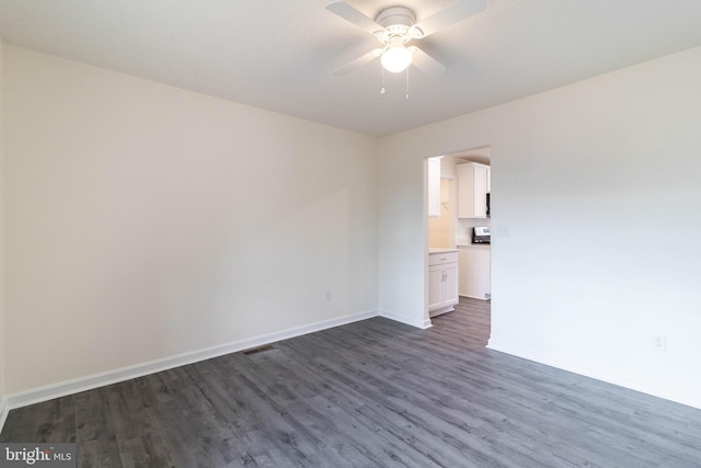 spare room featuring dark hardwood / wood-style floors and ceiling fan