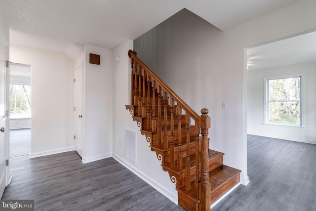 staircase featuring wood-type flooring and a textured ceiling